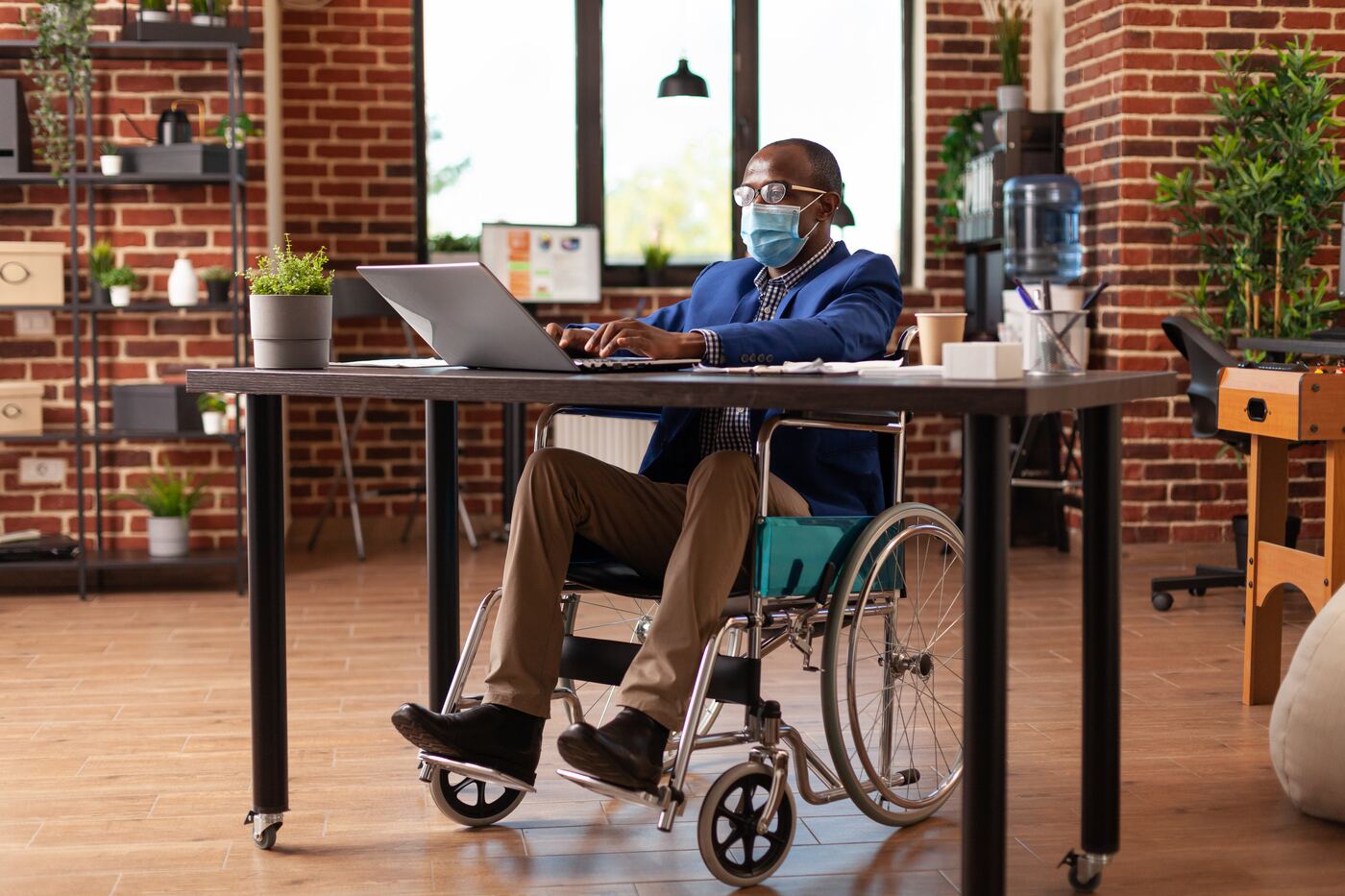 Man in a wheelchair working at an office desk